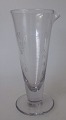 Messglas, 19. 
Jahrhundert. 
Klarglas. Mit 
Schleifen und 
Ätzen. Höhe:. 
12,2 cm.