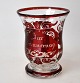 Deutscher 
Henkelbecher 
aus Glas, 19. 
Jh. Klarglas 
mit rotem 
Ûberfang. 
Geschliffen. 
Mit Text: Zur 
...