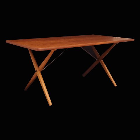 Hans J. Wegner: Savbukkebord med plade i teak og 
krydsbensstel i eg. H: 72cm. Plade: 159x85cm