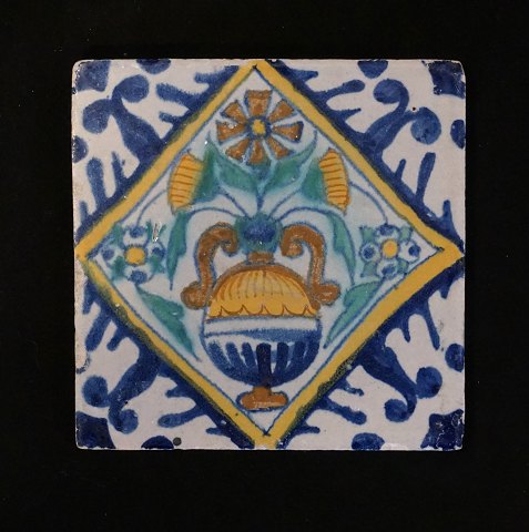 Polychromdekorierte holländische Fliese mit 
Blumenmotiv. Um 1620-40. Masse: 13x13cm