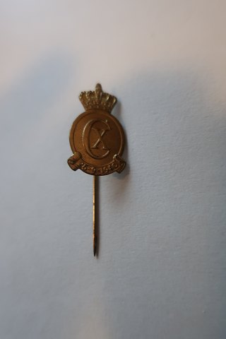 For samlere:
Ældre reversnål / Kongeemblem
Udført i gult metal med bogstaverne CX
Fremstillet efter en tegning af Poul Søbye (1889-1965)
Dateret: 26.9.1940
L: 4cm