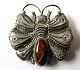 Art Nouveau 
Brosche aus 
Silber. U. 
1900. Mit 
Bernstein 
(defekt). 
Stempel: 825s. 
H: 6 cm, B: 6,5 
...