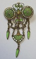 Italienische 
Brosche aus 
Messing mit 
grünen und 
weißen Emaille, 
um 1900. B:.. 
3,5 cm. H:. 6 
cm.