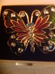 Brosche. 
Schmetterlinge 
mit Emaille und 
Strass-
Kristallen. 
Vergoldete 
Metall.