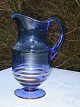 Glaskrug zu 
Fuss. Höhe 25 
cm. Zustand: 
Ein wenig 
Gebrauchsspuren 
an den 
Goldrändern.