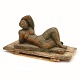 Laying woman. Sculpture of green and brown glazed pottery. H: 35cm. L: 65cm. W: 
31cm