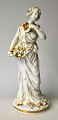 Capo di Monte 
Porzellanfigur, 
Frau mit Maske 
und Blumen. 
Glasiert und 
vergoldet. 
Italien des 20. 
...