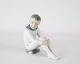 Porcelænsfigur, 
siddende dreng, 
nr.: 1742 af 
Bing og 
Grøndahl.
13 x 12 cm.

