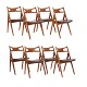 Hans J. Wegner: Satz von acht "Sawbuck"-Stühlen aus Teak mit originalem 
Lederbezug. Gestempelt Hans J. Wegner & Carl Hansen & Søn. Schöner Zustand mit 
kleineren Gebrauchsspuren. H Rücken: 75cm. H Sitz: 44,5cm