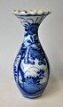 Arita Vase, 
Japan, 19. Jh. 
Blau mit Blumen 
bemalt. Mit 
gerüschtem 
Rand. H.: 19,5 
cm.