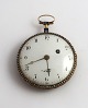 Nolls. Goldene Taschenuhr mit Emaille-Rückseite (750). Werknummer 1393. 
Durchmesser 50 mm. Kleinere Defekte am emaille. Kleinere Löcher an der Seite. 
Uhrwerk funktioniert nicht.