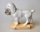 Porzellanfigur 
eines 
Pudelhundes mit 
Korb, 
Deutschland des 
19. 
Jahrhunderts. 
Vergoldung am 
Korb ...