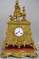 Französische 
Kaminuhr aus 
vergoldeter 
Bronze, 
Frankreich, ca. 
1819, Basis mit 
Rokoko-Muster 
und ...