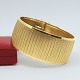 Wide bracelet 
in 18k gold