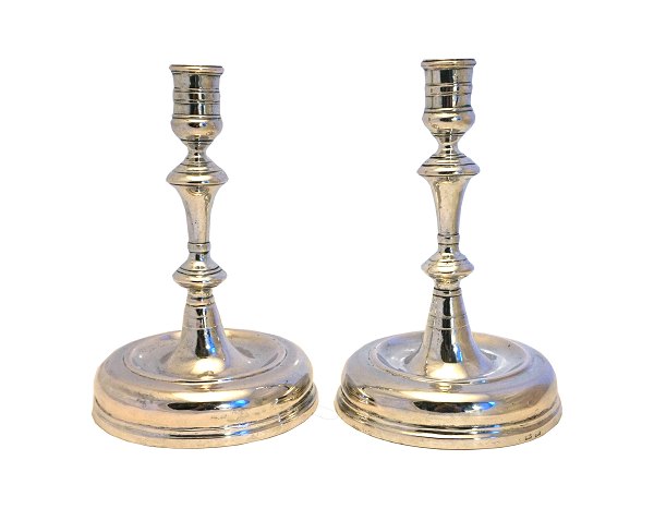 A pair of silver candle holders with feet. Around 1750