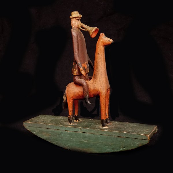 A Wood carved man on a horse playing the trumpet. Sweden circa 1880. H: 25,5cm. 
L: 25cm