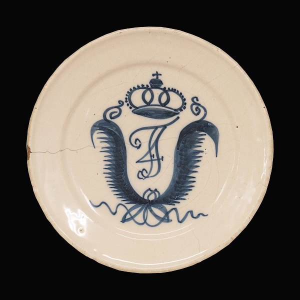 Tidlig St. Kongensgade tallerken i fajance. Prydet med Frederik IVs kronedes 
monogram. Fremstillet ca. år 1730. D: 22,5cm